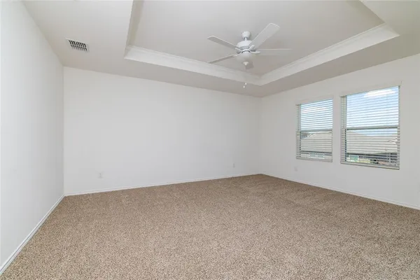 an empty room with windows and fan