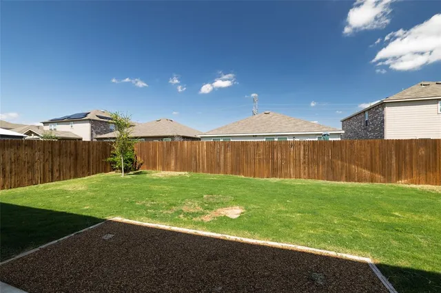 a view of a backyard with table and chairs a wooden fence