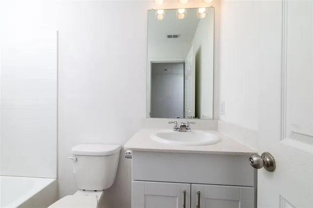 a bathroom with a sink toilet and mirror
