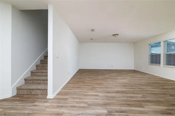 a view of an empty room with stairs and ventilation