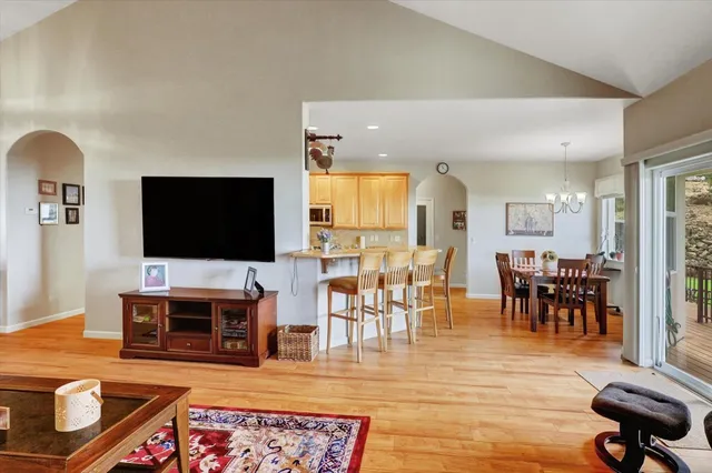 a kitchen with stainless steel appliances granite countertop a refrigerator a sink dishwasher a stove and white countertops with wooden floor