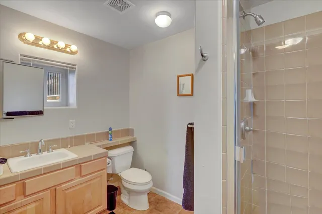 a backyard of a house with table and chairs under an umbrella