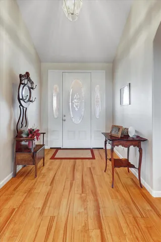 a view of a dining room with furniture a chandelier and wooden floor