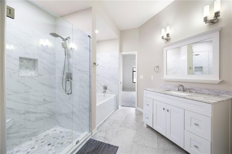 5300 Peachtree Road, Unit 3207 Chamblee, GA 30341 - Photo 18 of 25 a bathroom with a granite countertop sink a mirror a bathtub and shower