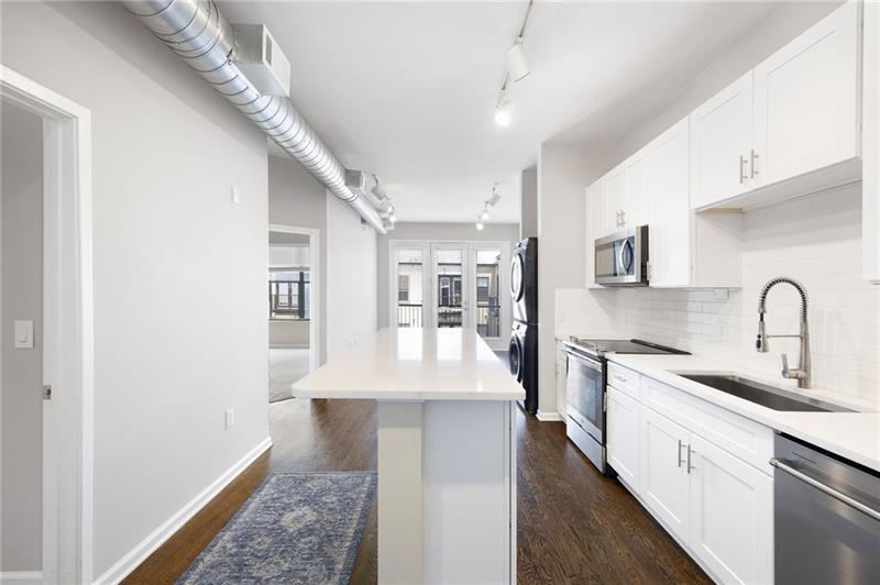5300 Peachtree Road, Unit 3207 Chamblee, GA 30341 - Photo 5 of 25 a large white kitchen with kitchen island a sink stainless steel appliances and cabinets