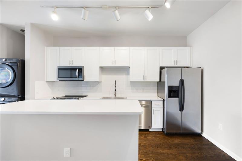 5300 Peachtree Road, Unit 3207 Chamblee, GA 30341 - Photo 7 of 25 a kitchen with stainless steel appliances a refrigerator a sink a stove a microwave and cabinets