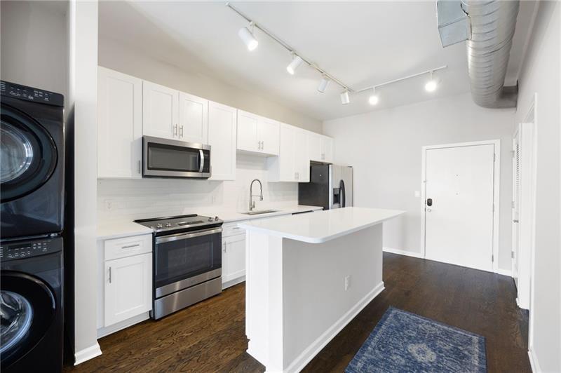 5300 Peachtree Road, Unit 3207 Chamblee, GA 30341 - Photo 8 of 25 a kitchen with stainless steel appliances a stove a sink a microwave a refrigerator and cabinets