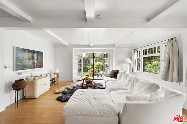 a living room with furniture large window and a table