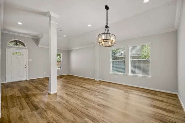 a view of an empty room with window and wooden floor