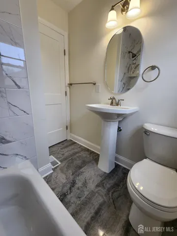 a bathroom with a toilet sink and mirror
