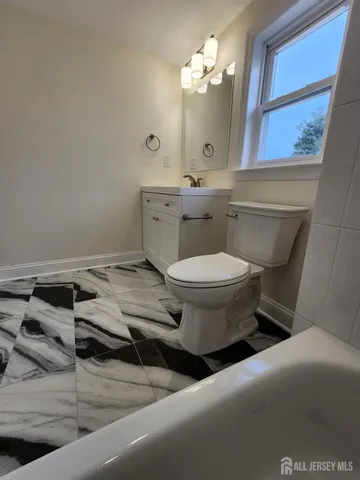 a bathroom with a toilet sink and mirror