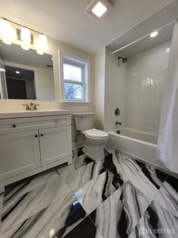 a bathroom with a sink a toilet a mirror and shower