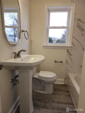 a bathroom with a sink toilet and a mirror