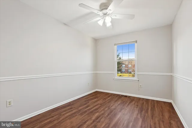 an empty room with a window and wooden floor