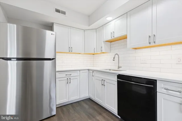 a kitchen with a sink a refrigerator and cabinets