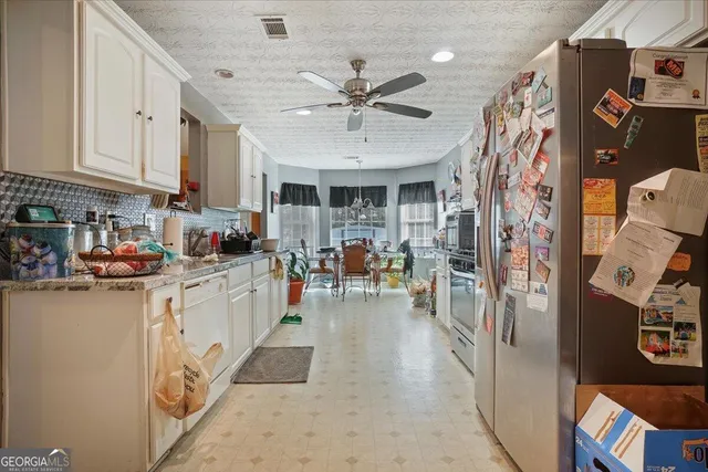 a kitchen with stainless steel appliances granite countertop a refrigerator and a stove top oven