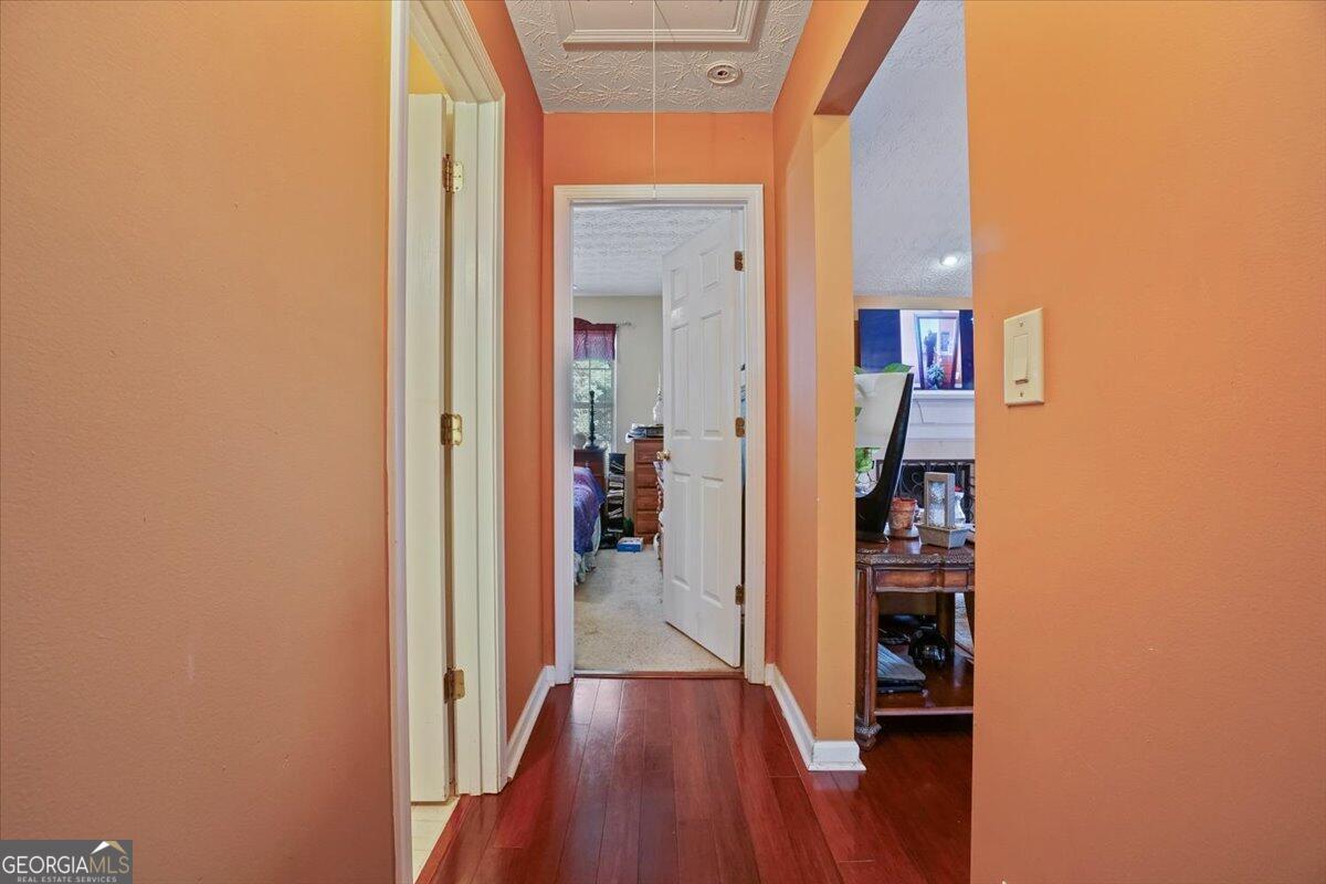 915 Harbins View Drive Dacula, GA 30019 - Photo 20 of 26 a view of a hallway with wooden floor and a living room