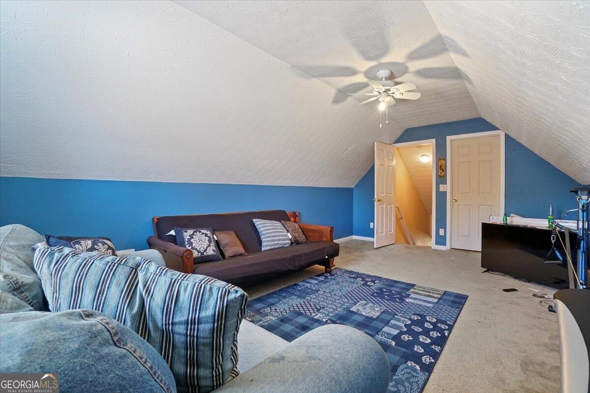 915 Harbins View Drive Dacula, GA 30019 - Photo 25 of 26 a living room with furniture and a chandelier