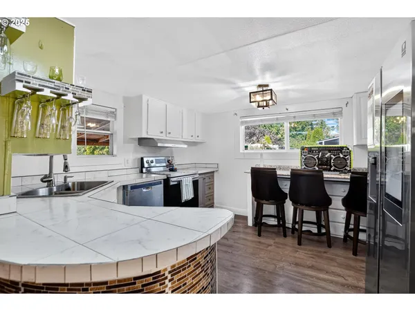 a living room with stainless steel appliances kitchen island granite countertop furniture a refrigerator and sink