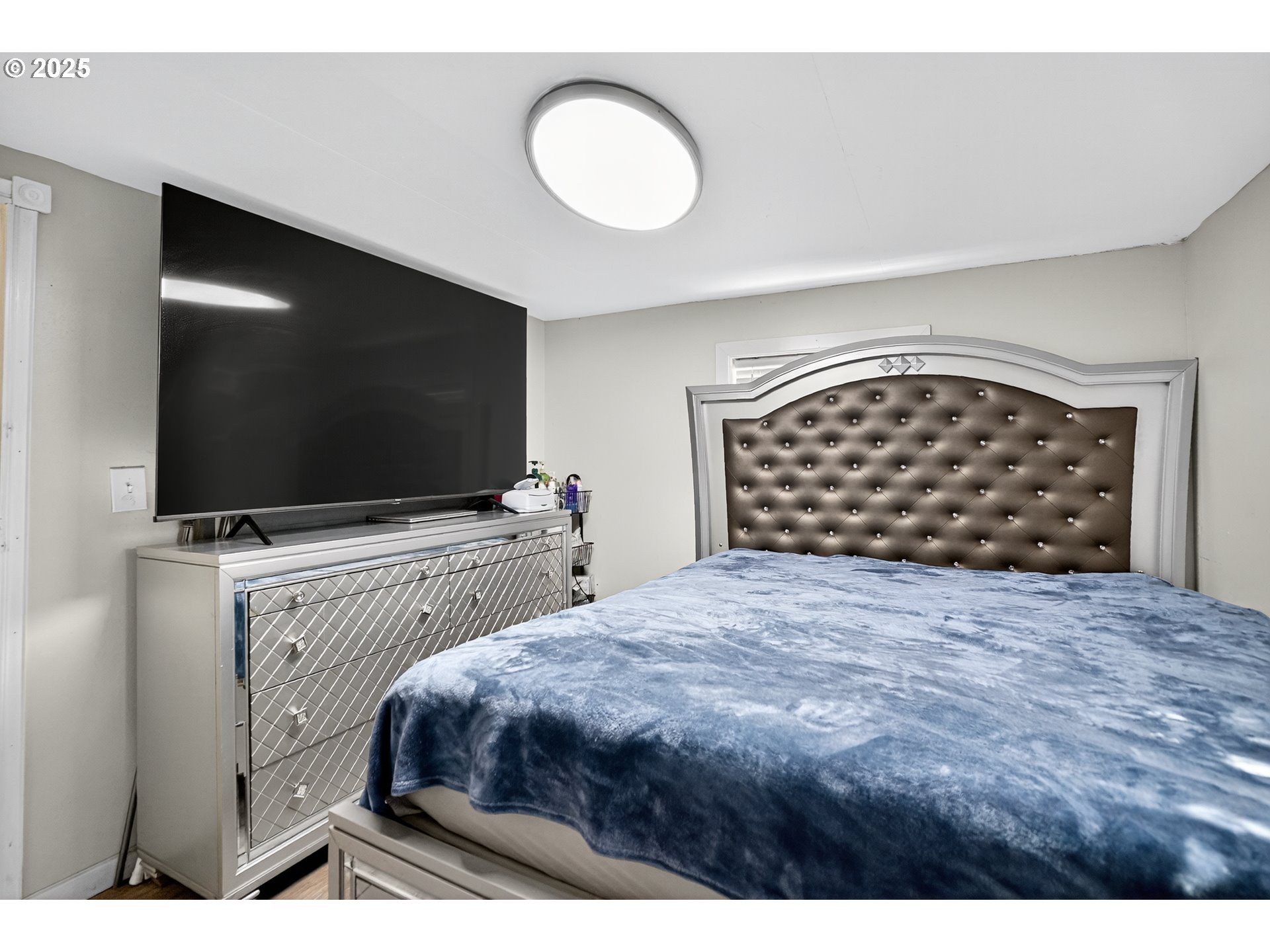 8525 Southeast Orchard Lane, Unit 84 Happy Valley, OR 97086 - Photo 19 of 25 a bedroom with a bed and a flat screen tv