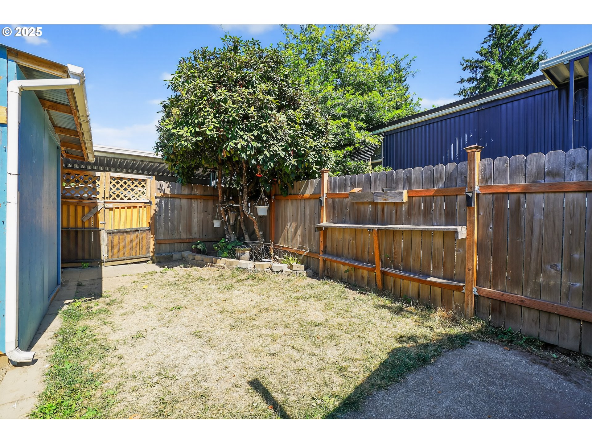 8525 Southeast Orchard Lane, Unit 84 Happy Valley, OR 97086 - Photo 22 of 25 a view of backyard with wooden fence and large trees