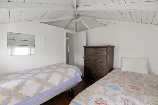 a spacious bedroom with a bed a dresser and next to a window