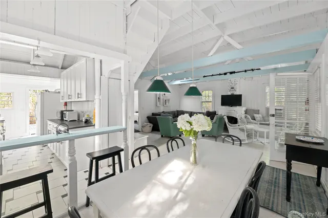 a view of a dining room with furniture one side kitchen view and wooden floor