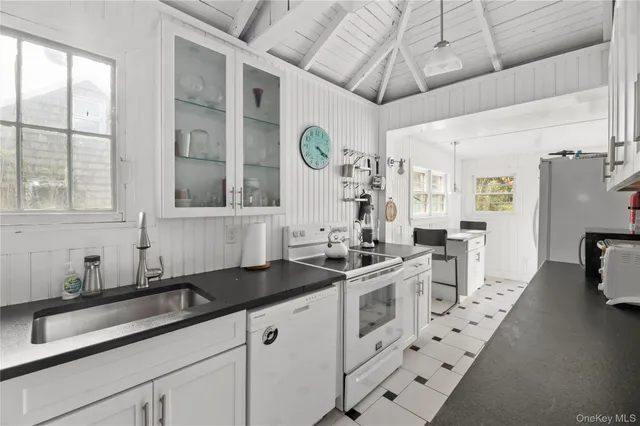 a kitchen with stainless steel appliances a sink a stove a counter space and a window