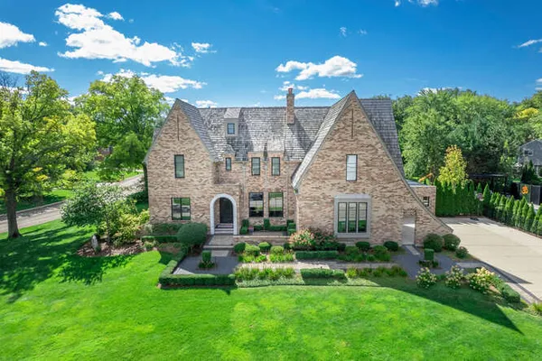 a front view of a house with a yard and potted plants