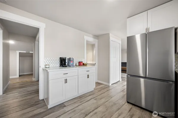 a kitchen with wooden floors white cabinets and stainless steel appliances