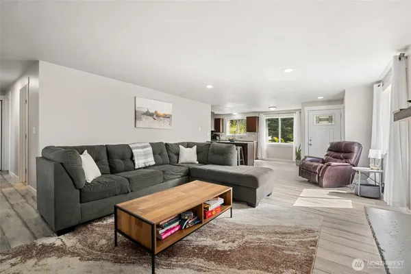 a living room with furniture a rug and a window