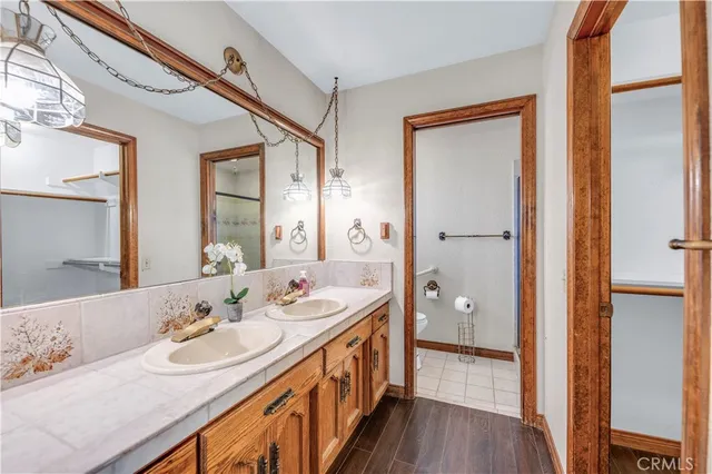 a bathroom with a double vanity sink and mirror with shower