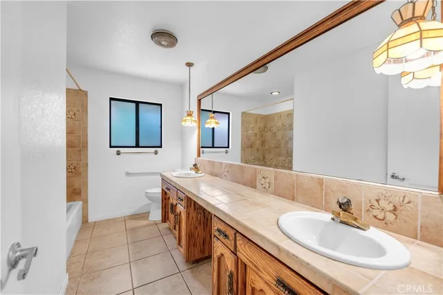 an empty room with wooden floor ceiling fan and windows