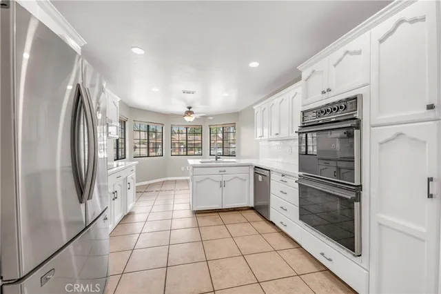 a kitchen with a refrigerator a stove top oven and cabinets