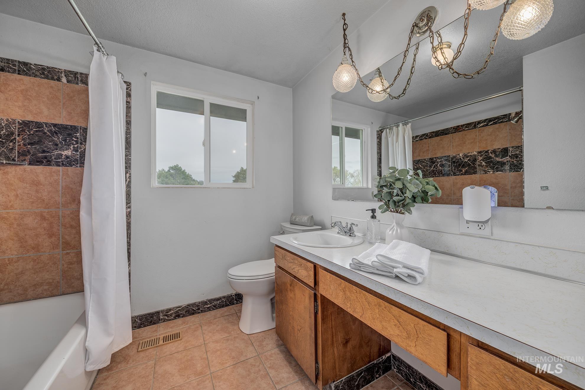 4484 Community Road Ontario, OR 97914 - Photo 11 of 35 Full bathroom featuring vanity, light tile patterned floors, and shower / bathtub combination with curtain