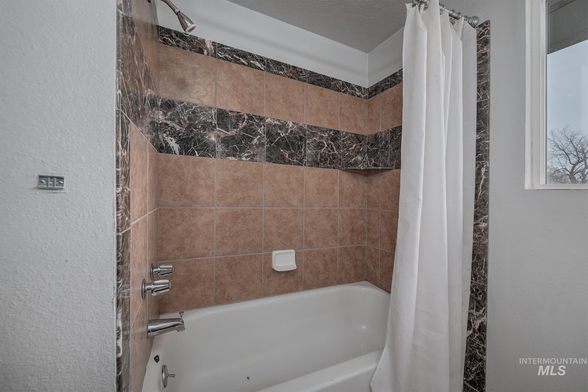 4484 Community Road Ontario, OR 97914 - Photo 12 of 35 Bathroom featuring a textured wall and shower / bathtub combination with curtain