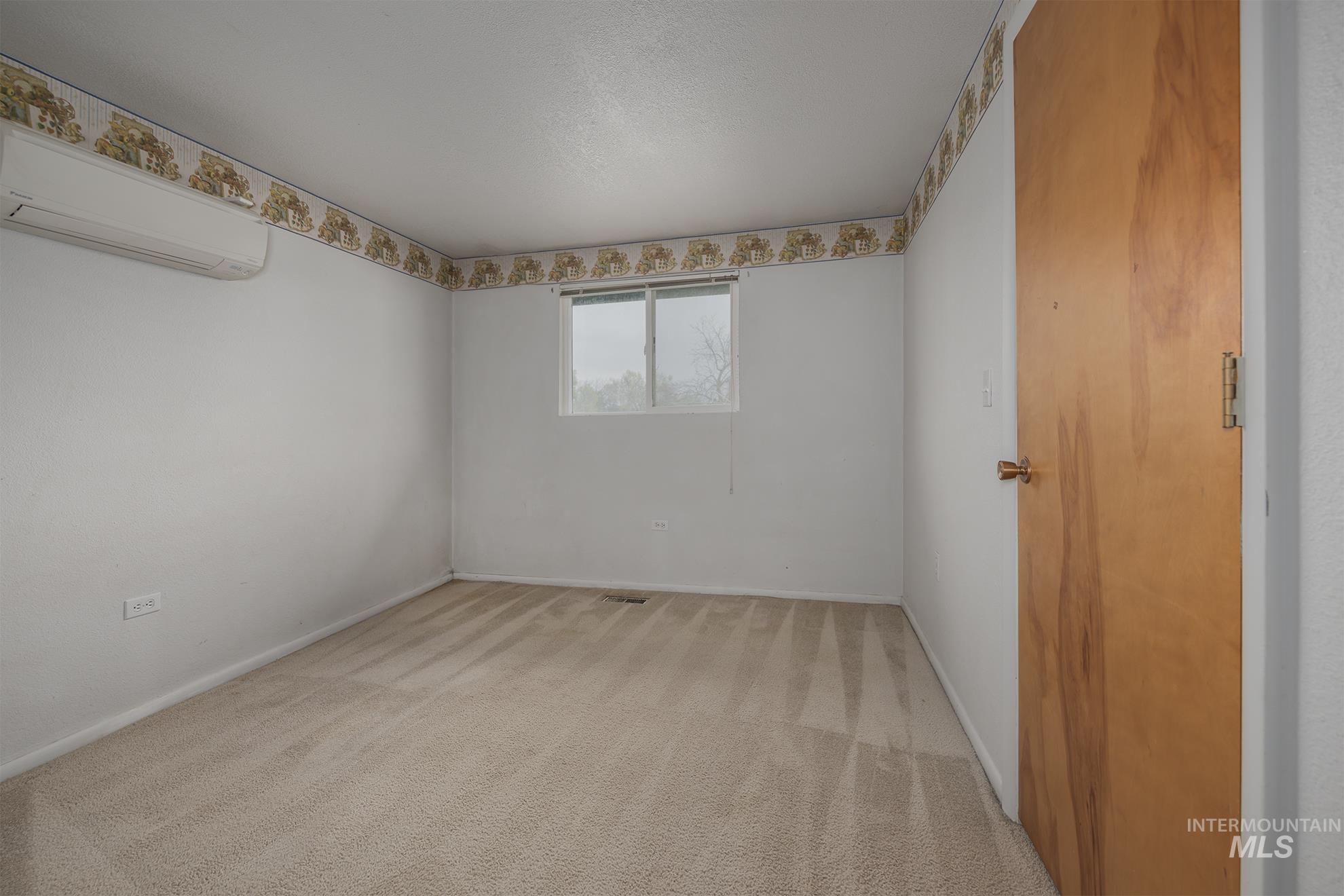 4484 Community Road Ontario, OR 97914 - Photo 14 of 35 Spare room with a wall mounted mini split and light colored carpet