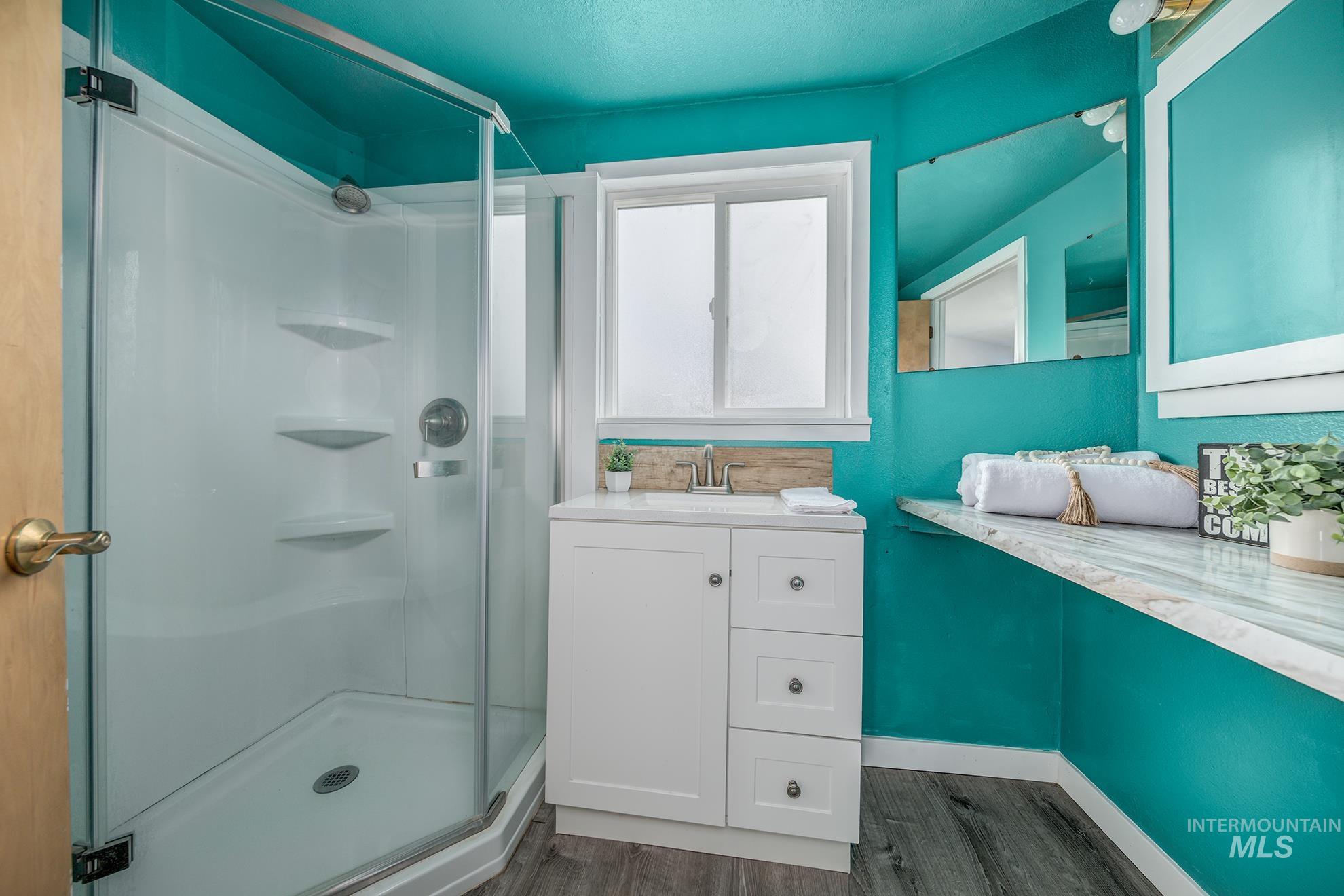 4484 Community Road Ontario, OR 97914 - Photo 15 of 35 Full bathroom featuring vanity, a stall shower, and dark wood-type flooring