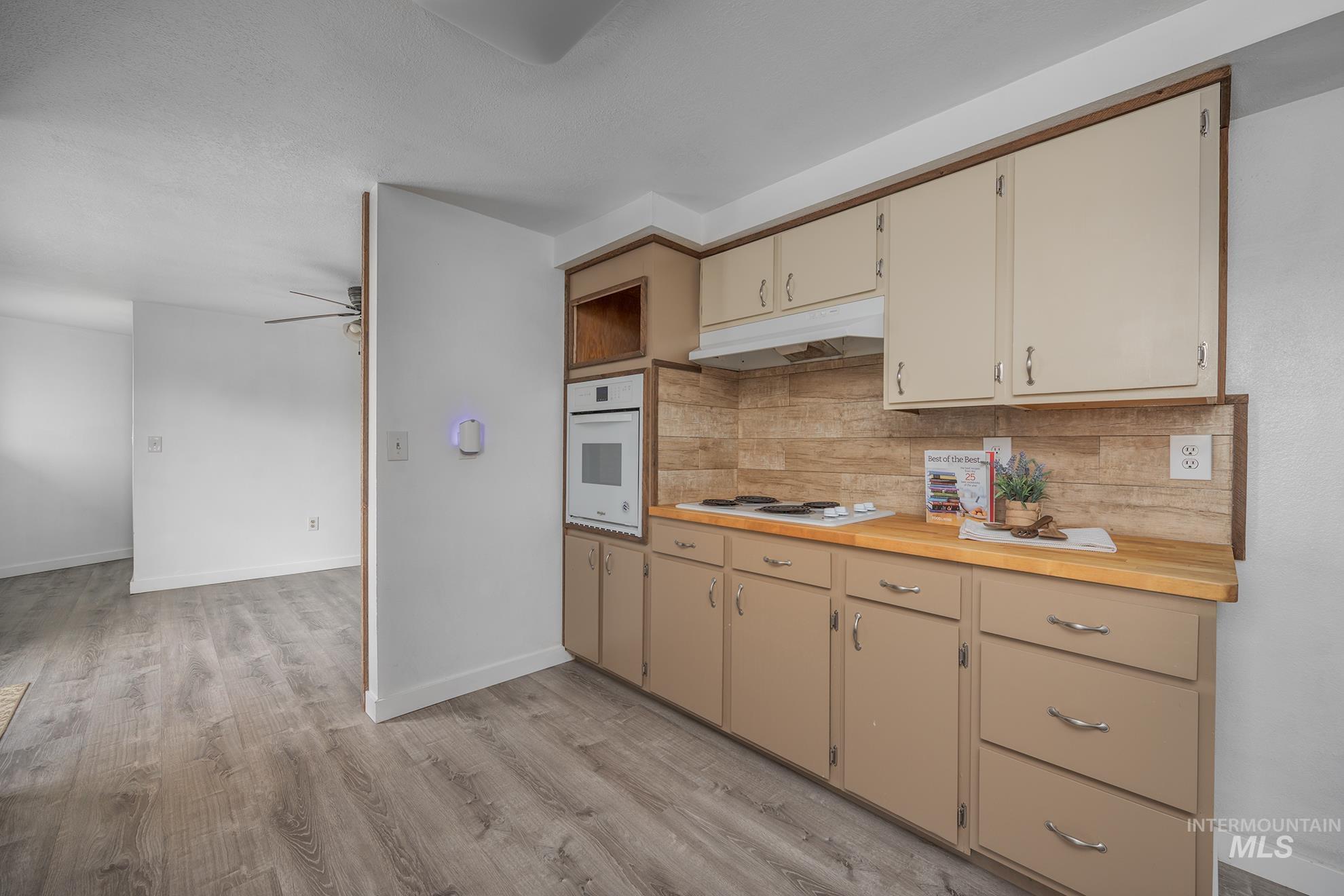 4484 Community Road Ontario, OR 97914 - Photo 4 of 35 Kitchen with cream cabinetry, white appliances, butcher block counters, and backsplash