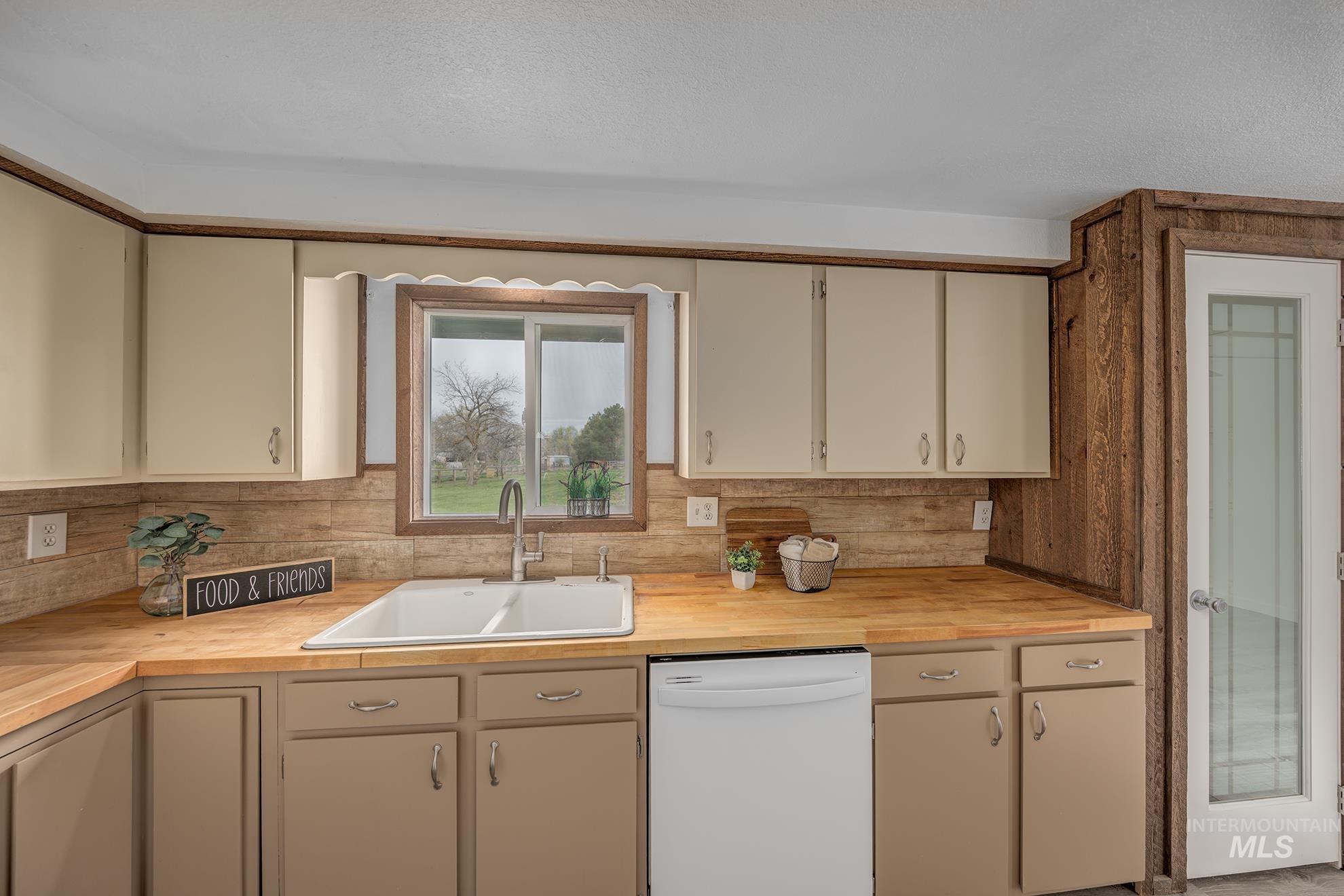4484 Community Road Ontario, OR 97914 - Photo 5 of 35 Kitchen with white dishwasher, wooden counters, cream cabinets, and a textured ceiling