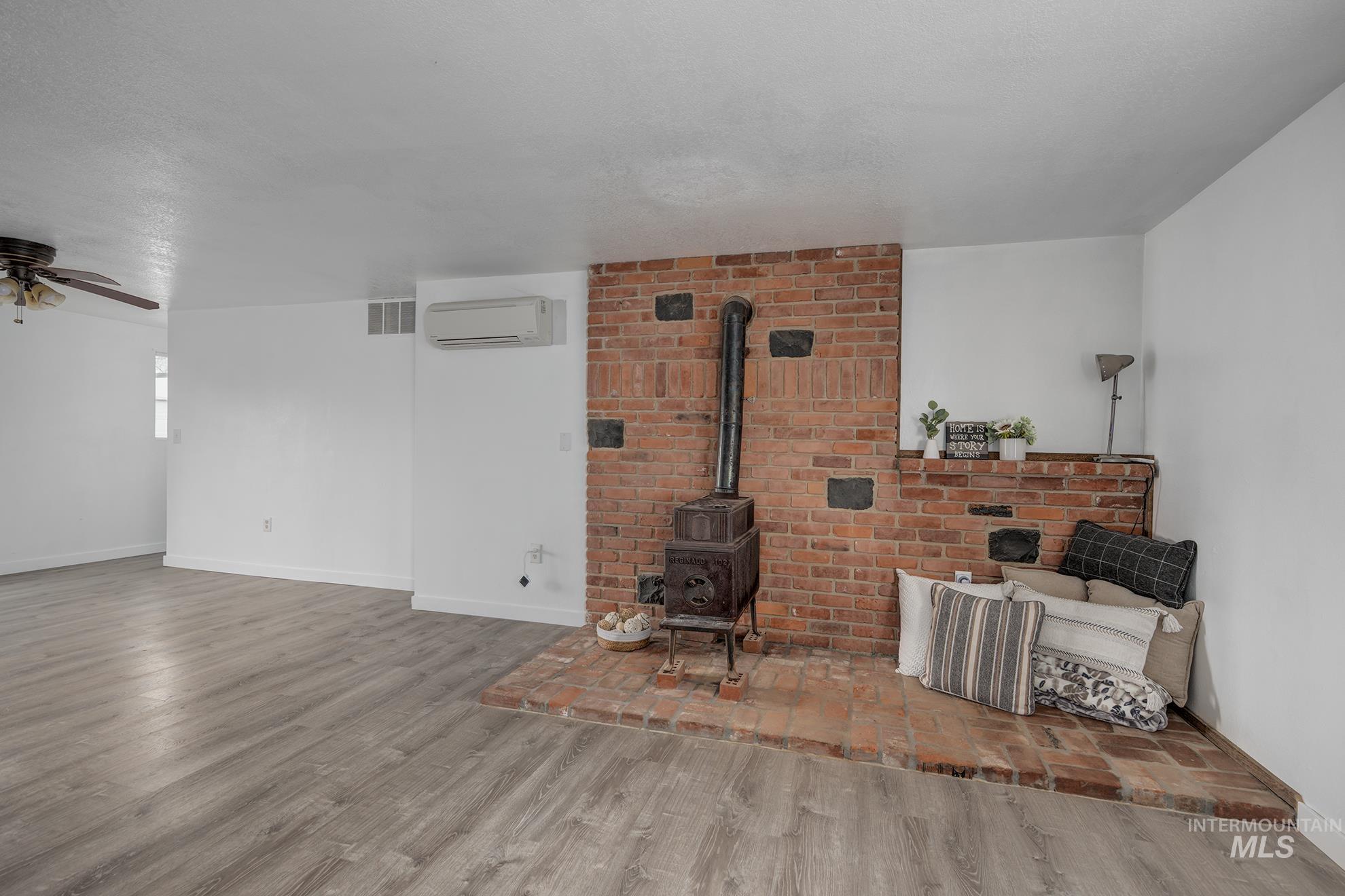 4484 Community Road Ontario, OR 97914 - Photo 7 of 35 Living area with wood finished floors, ceiling fan, and a wood stove