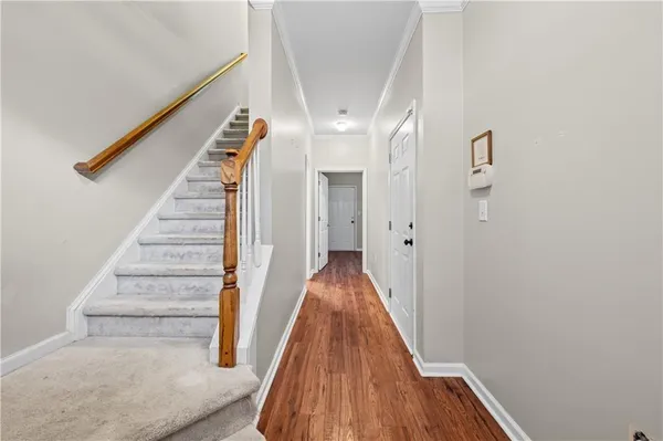 a view of a hallway with wooden floor and staircase