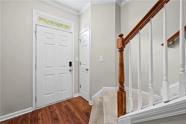 a view of a hallway with wooden floor and staircase