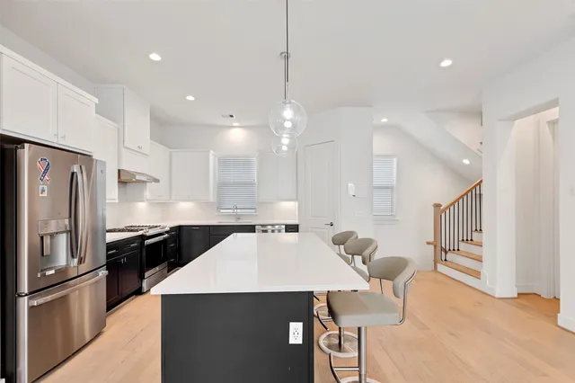 a large kitchen with kitchen island a sink a stove a center island a stove and a window