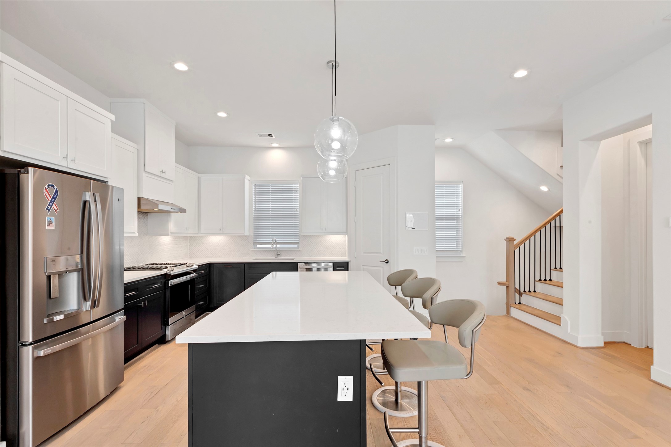 1740 Ojeman Point Lane Houston, TX 77055 - Photo 6 of 20 a kitchen with stainless steel appliances kitchen island granite countertop a refrigerator a sink dishwasher a stove and white cabinets with wooden floor