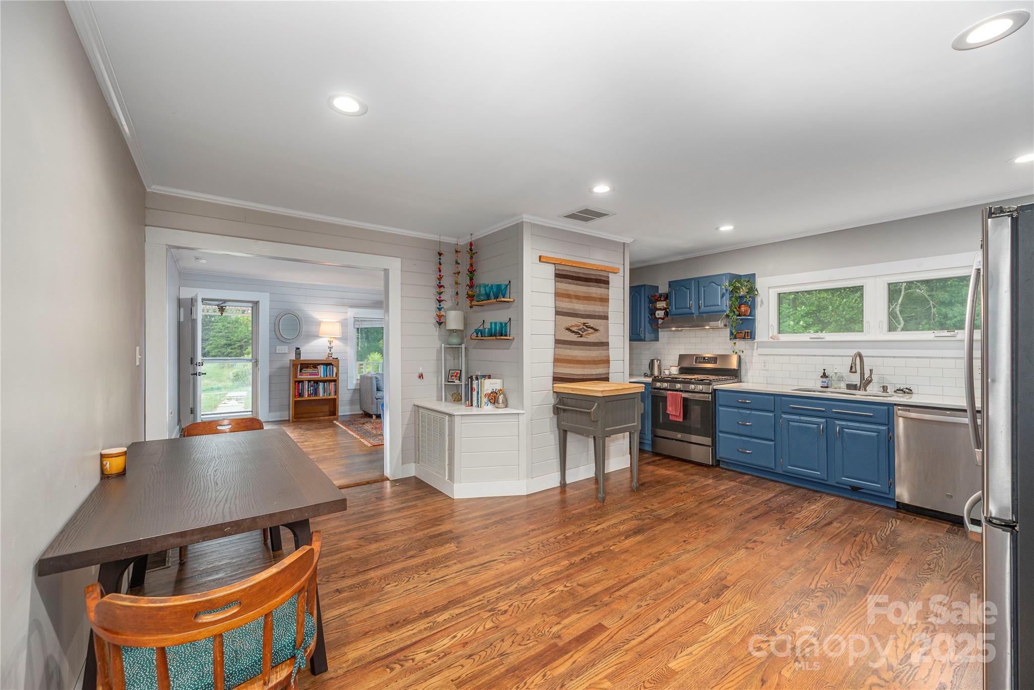 1304 Souther Road Old Fort, NC 28762 - Photo 14 of 48 a kitchen with stainless steel appliances kitchen island granite countertop a refrigerator a stove top oven and a dining table with wooden floor