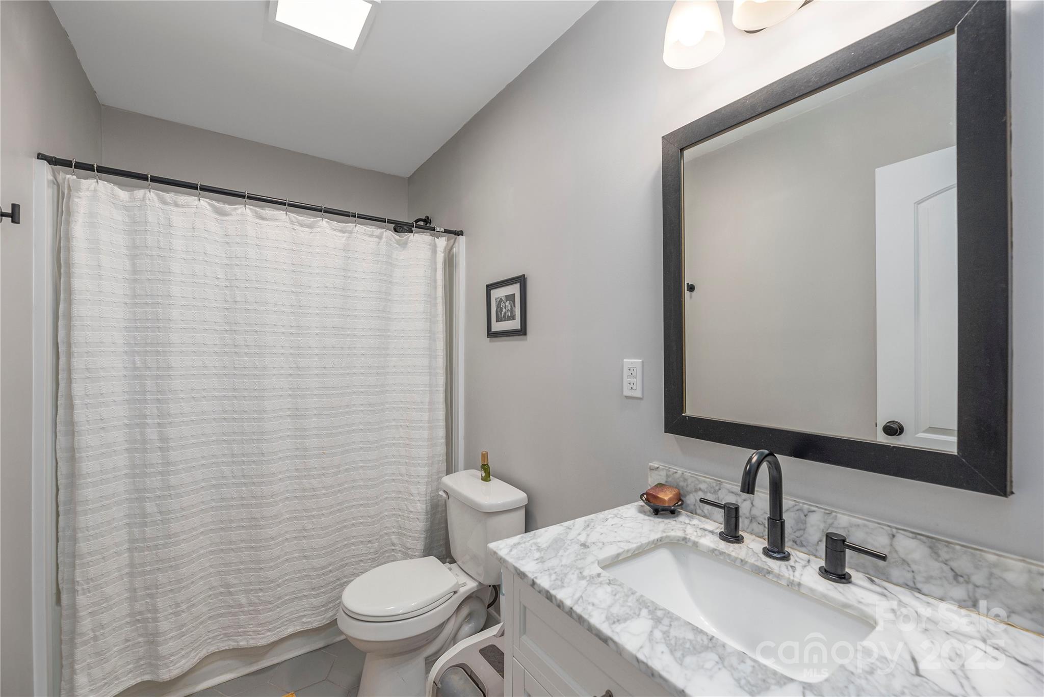 1304 Souther Road Old Fort, NC 28762 - Photo 24 of 48 a bathroom with a granite countertop sink toilet and a mirror