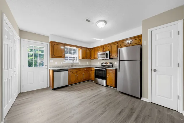 a kitchen with refrigerator a sink and a microwave