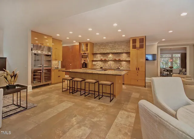 a living room with furniture a fireplace and a floor to ceiling window