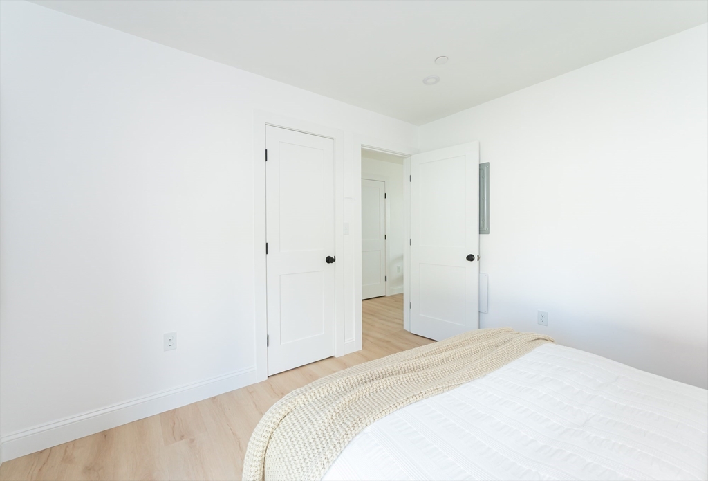 7 Kenoza Avenue, Unit 101 Haverhill, MA 01830 - Photo 14 of 21 a bedroom with a bed and a wall painting